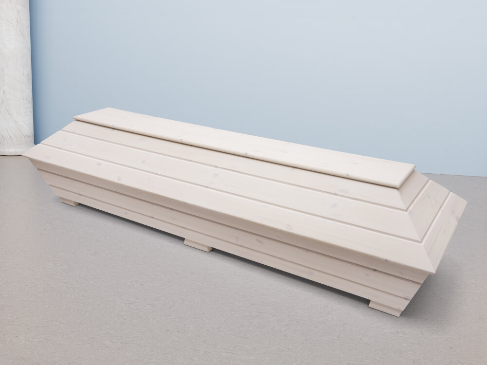 Vaalea puuarkku, puun pinta kuultaa ohuen pintakäsittelyaineen läpi. Kannessa ja pohjassa on näkyvät pitkittäiset vaot osien välillä.